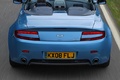 Aston Martin V8 Vantage Roadster bleu face arrière travelling vue de haut debout