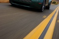 Aston Martin V8 Vantage vert 3/4 avant gauche travelling penché debout