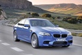 BMW M5 2011 bleu 3/4 avant droit travelling penché
