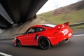 Porsche 997 GT2 RS rouge 3/4 arrière gauche travelling penché 2