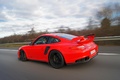 Porsche 997 GT2 RS rouge 3/4 arrière gauche travelling penché 3