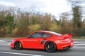 Porsche 997 GT2 RS rouge 3/4 arrière gauche travelling penché 4