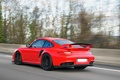Porsche 997 GT2 RS rouge 3/4 arrière gauche travelling penché 5