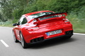 Porsche 997 GT2 RS rouge 3/4 arrière gauche travelling penché