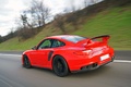 Porsche 997 GT2 RS rouge 3/4 arrière gauche travelling penché