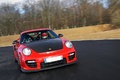 Porsche 997 GT2 RS rouge 3/4 avant droit travelling penché