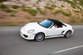 Porsche Boxster Spyder blanc 3/4 avant gauche capoté travelling penché vue de haut